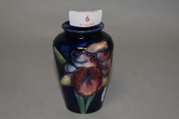 An early 20th century small sized Moorcroft pottery vase signed in green with a blue ground. 9cm
