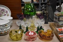 Three art glass trinket dishes with four green stem wine glasses, five yellow stem glasses and a