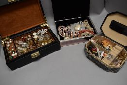 A selection of vintage enamel pin badges and a selection of simulated pearl necklaces.