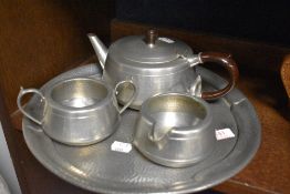 A vintage hammered pewter tea pot, tray, sugar basin and jug.
