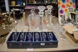 A selection of clear cut crystal glass wares including 2 ships decanters, two sets of six etched