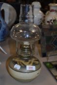 A vintage unmarked studio pottery oil lamp with glass chimney.