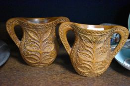 A pair of carved wood handled vases, having floral decoration.