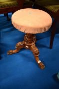 A Victorian mahogany revolving adjust piano stool having foliate column and triple splay legs