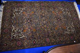 A traditional fireside rug, heavily patterned with rich colours approx. 168 x 102cm