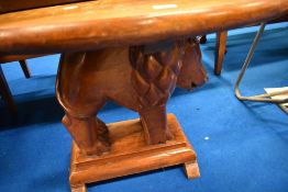 An exotic hardwood coffee table having oval top with support modelled as lion