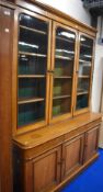 A Victorian golden oak full height bookcase, having triple glazed section over concealed drawers and