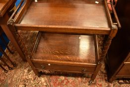 An early 20th Century oak tea trolley having tea towel rails, barley twist supports and lower