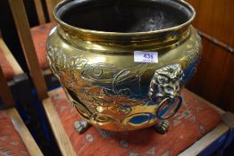 A brass planter having vine decoration and lion mask handles