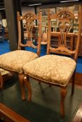 A pair of Victorian bleached mahogany dining chairs having overstuffed seats