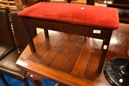A vintage mahogany piano stool having burgundy dralon top