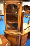 A reproduction mangoany/walnut corner display with cupboard under