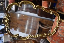 A vintage giltwood wall mirror having scroll frame