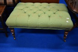 A reproduction Victorian style footstool of large proportions having turned legs and button