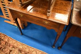 A Georgian oak side table having single frieze drawer over shaped apron
