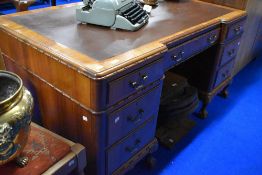 An early 20th Century breakfront pedestal desk having moulded edge and ball and claw feet, width
