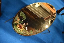 A vintage oval wall mirror with crinoline lady decoration