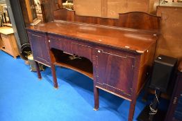A late 19th or early 20th Century mahogany sideboard having central drawer and shelf, flanked by