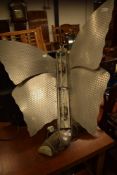 An Art Deco Butterfly form room heater converted into a lamp, in aluminium on a swivel arm branch on
