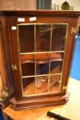 A reproduction mahogany corner wall display