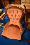 A reproduction mahogany framed balloon back nursing chair having pink dralon upholstery and button