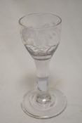 An 18th century cordial glass having a simple bell form bowl with etched floral design on a thick
