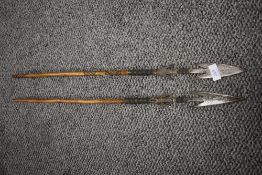 Two early 20th century ethnic tribal fishing spears with iron heads and carved shafts.
