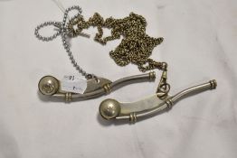 Two 20th century bosun's whistles both bearing a military arrow mark.