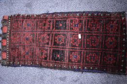 A 20th century Persian Afghan Balouch salt bag in woven wool in a black and red ground 110cm x 48cm