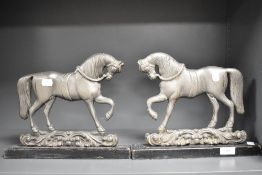 A pair of Victorian fire side ornaments or door stops in the form of military style horses.