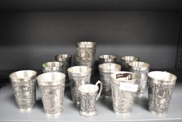 Fourteen Zinn Becker German Pewter cups having traditional designs.