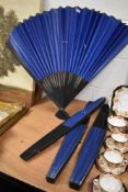 Four large decorative oriental fans having ebonised frames with plain fan cover.