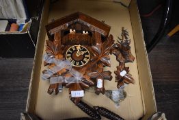 A vintage mid century coo coo or Cuckoo clock having a carved Black Forrest design with couples