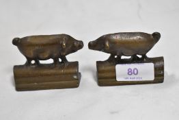 A pair of small bronze cast mirrored pig ornaments.