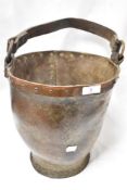 A Victorian animal hide fire bucket with leather handle and copper rim.