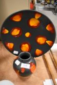 Two pieces of mid century Poole Pottery including a display plate and squat vase in the Lava