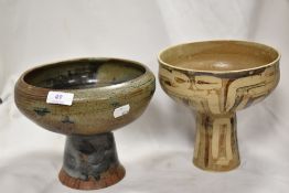 An unmatched pair of Studio pottery pedestal bowls both having earthen glazes with abstract