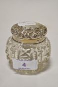 An early 20th century clear cut crystal glass jar with HM silver lid with embossed design.