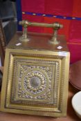 A brass coal bucket having an embossed sun flower design.