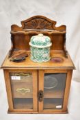 An early 20th century tobacco pipe smokers compendium cabinet, having an Oak case with glazed