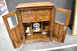 A fine early 20th century tobacco smokers pipe cabinet, having oak case with bevel edged glass