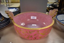 A Victorian pink glass bowl with twin leaf form handles and decorated with gilt foliate details.