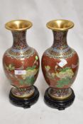 A pair of modern oriental cloisonne vases in baluster form with red ground over yellow metal wire,