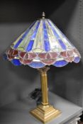 A vintage light having classical brass column with a leaded light shade.