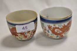 A pair of antique Japanese porcelain sake bowls having iron red dragon decoration. Both bearing four