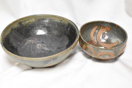 Two studio pottery bowls in earthen ware glazes with abstract designs.