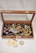 A box of costume jewellery including necklaces, simulated pearls and collectable coins.
