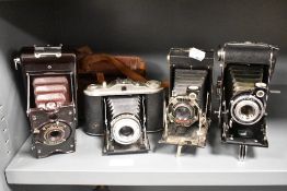 Four early 20th century photographic cameras including Agfa, Kodak and Soho model B.