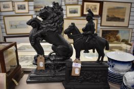 Two Victorian cast iron door stops in the form of a rampant lion and a military officer of horse