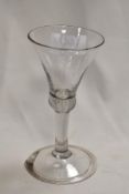An 18th century wine glass having trumpet form bowl with knopped stem on domed and folded foot.